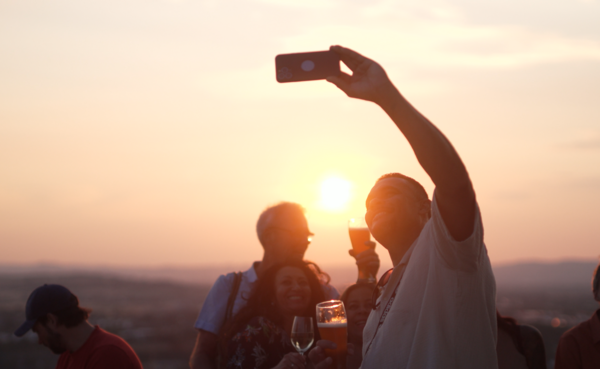 Mann macht von sich ein Selfie, im Hintergrund Sonnenuntergang  ©PlusPunktFilm