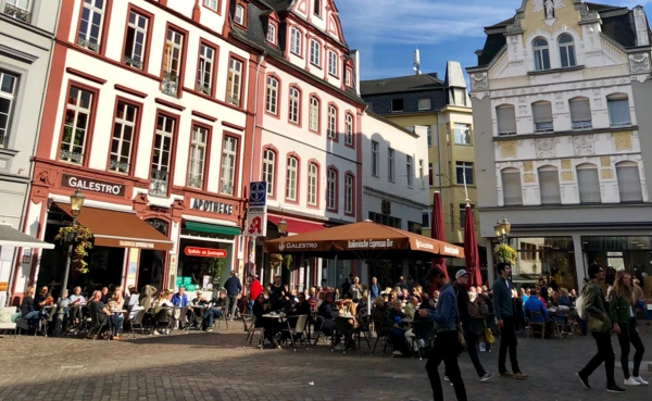 Menschen sitzen an Cafétischen in der Koblenzer Altstadt