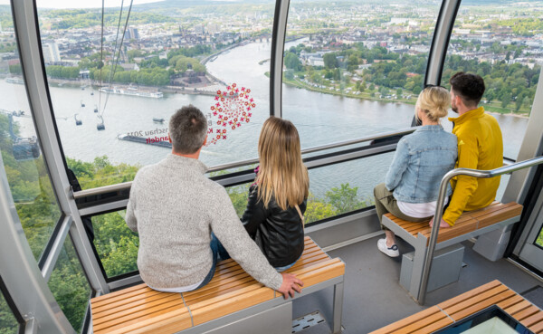 4 Personen in einer Kabine der Seilbahn Koblenz mit Blick auf dem Rhein, der Mosel und dem Deutschen Eck im Hintergrund ©Koblenz-Touristik GmbH, Dominik Ketz