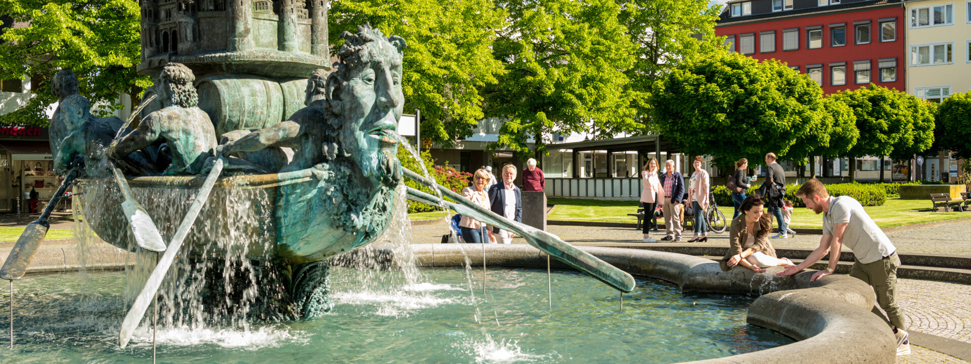 Brunnen "Historiensäule" auf dem Görresplatz in Koblenz umgeben von kleinen Menschengruppen ©Koblenz-Touristik GmbH, Dominik Ketz