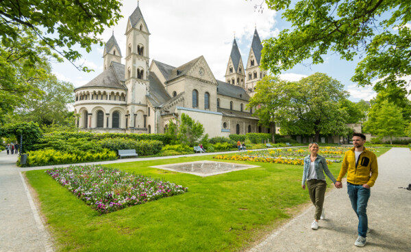 Pärchen geht Hand in Hand durch den Blumenhof hinter Basilika St. Kastor © Koblenz-Touristik GmbH, Dominik Ketz