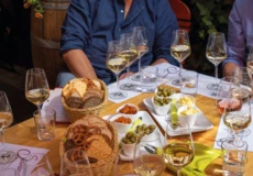 Bedeckter Tisch mit Brot, Häppche und vollen Weingläsern