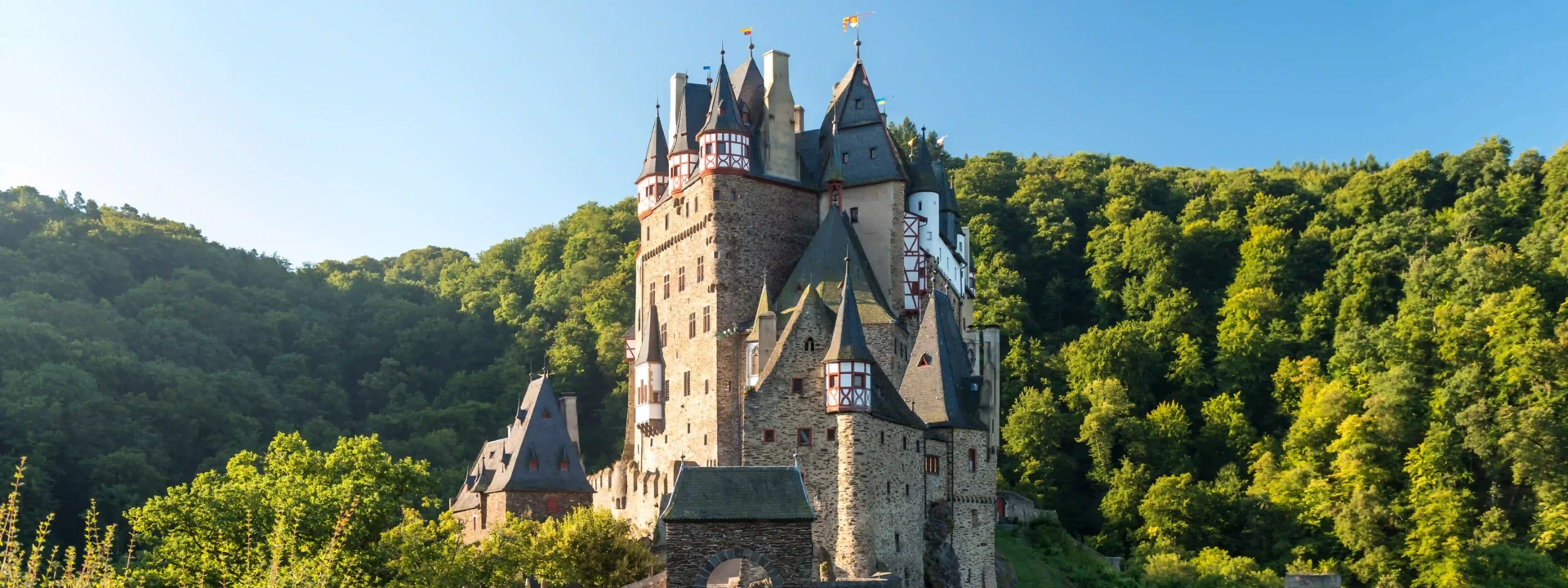 Die Burg Eltz von vorne umgeben vom gr&uuml;nen Wald &copy; Rheinland-Pfaltz Tourismus GmbH, Dominik Ketz