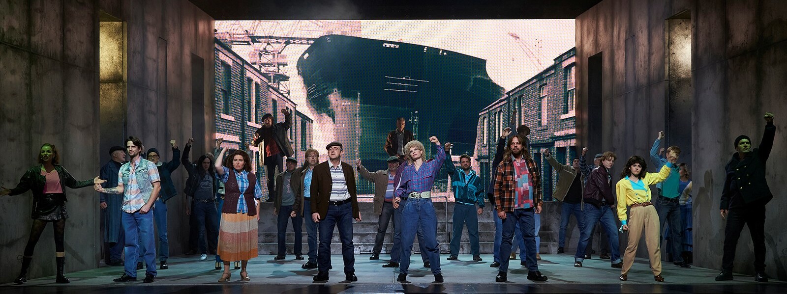 Darsteller auf einer Buhne stehen vor einer Leinwand mit einem Bild von einem Schiff ©Theater Koblenz