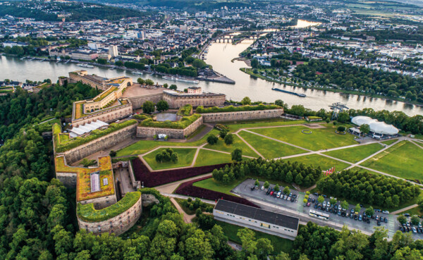 Luchtfoto van Festung Ehrenbreitstein met op de achtergrond het Deutsches Eck, de Rijn, de Moezel en de stad Koblenz ©Adobe Stock