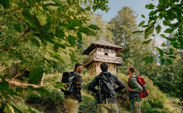 Wandergruppe steht vor einem Römerturm im Wald ©Koblenz-Touristik GmbH, Philip Bruederle