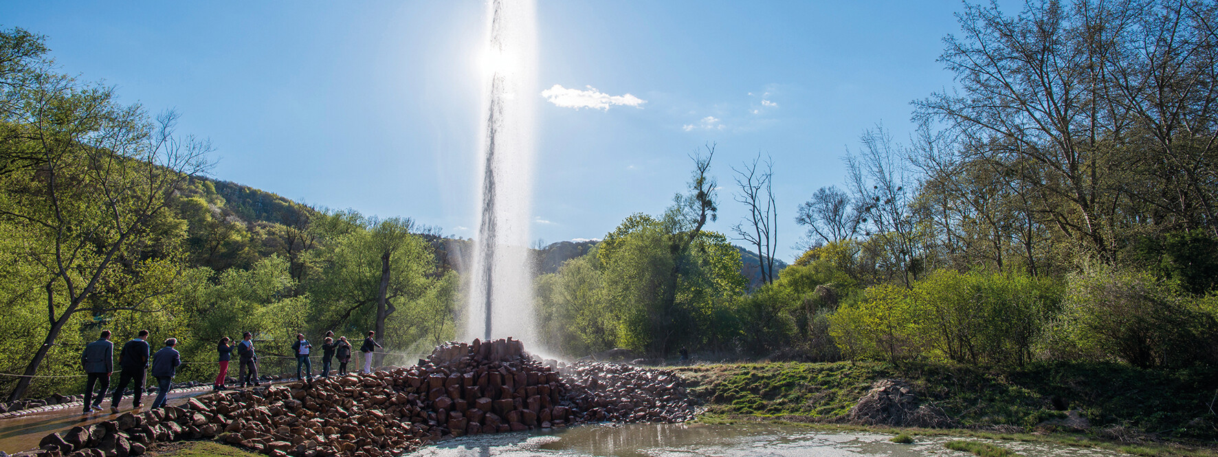 Geysir Andernach hinterbeleuchtet von der Sonne mit beobachtenden Menschen im Vordergrund ©Geysir.info GmbH, Klaus-Peter Kappes