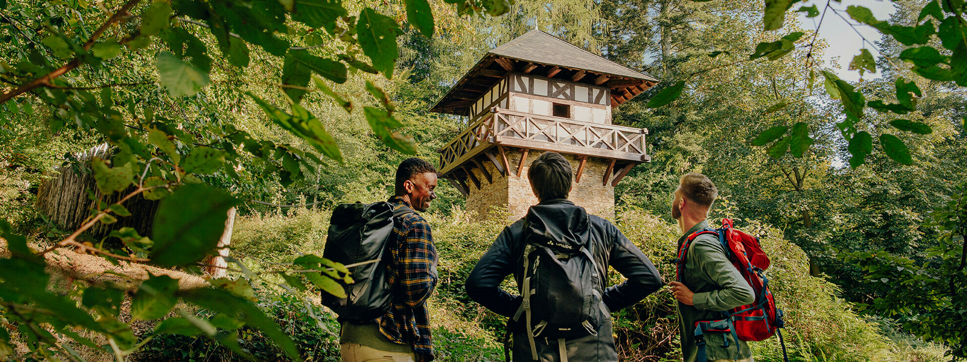 Wandergruppe steht vor einem Römerturm im Wald ©Koblenz-Touristik GmbH, Philip Bruederle