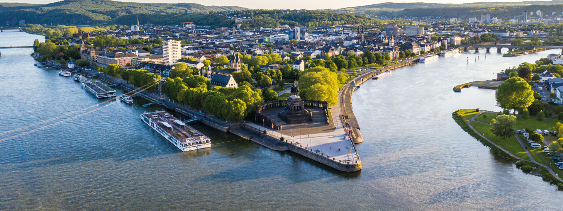 Luftaufnahme vom Deutschen Eck in Koblenz mit der Seilbahn, dem Rhein, der Mosel und Schiffen im Vordergrund ©Koblenz-Touristik GmbH, Dominik Ketz