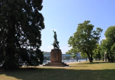 Görresdenkmal an den Rheinanlagen umgeben von Wiese und Bäumen