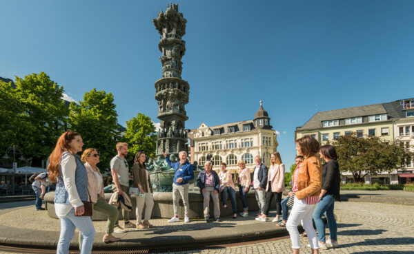 Touristen stehen auf dem Görresplatz und schauen sich die Historiensäule an. © Koblenz-Touristik GmbH, Dominik Ketz