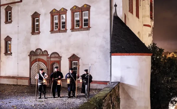 Stadtf&uuml;hrer verkleidet als Nachtw&auml;chter stehen vor der alten Burg in Koblenz &copy; Koblenz-Touristik GmbH / Picture Colada