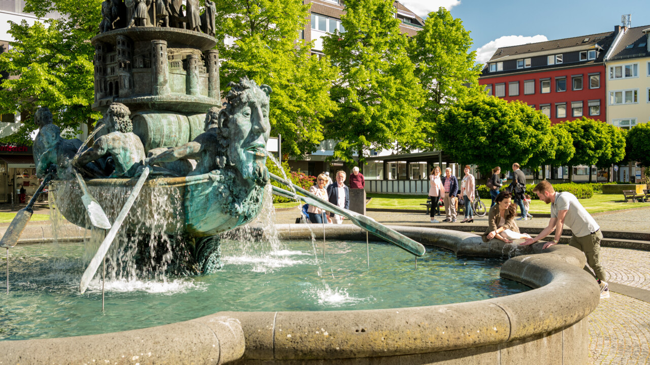 Brunnen "Historiensäule" auf dem Görresplatz in Koblenz umgeben von kleinen Menschengruppen ©Koblenz-Touristik GmbH, Dominik Ketz