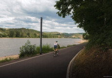 Rennradfahrer auf dem Rheinradweg mit dem Rhein und der Marksburg im Hintergrund © Ryne & Denise Cook