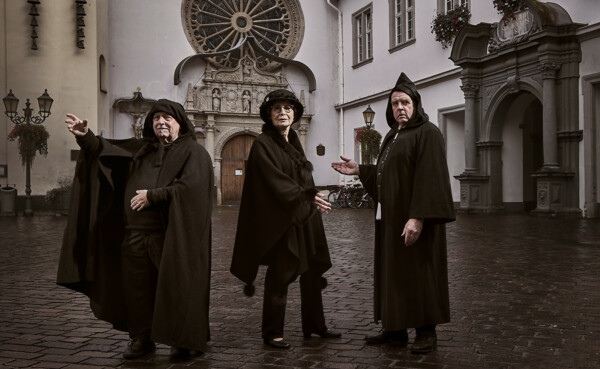Kostümierte Stadtführer*innen stehen auf dem Jesuitenplatz in Koblenz bei Nacht © Koblenz-Touristik GmbH, Picture Colada
