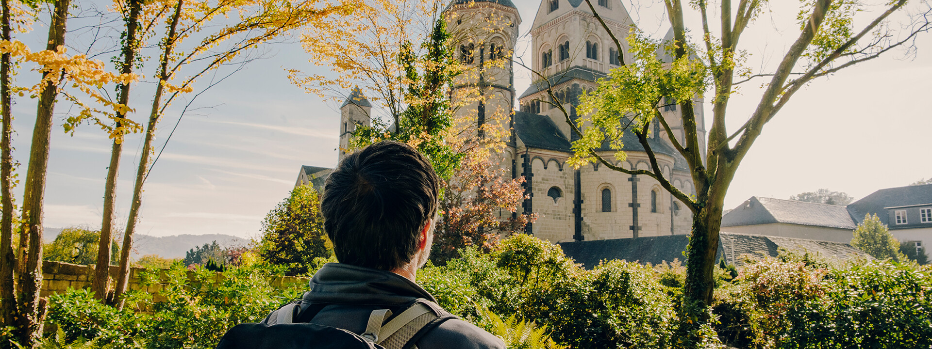 Mann von hinten blickt auf das Kloster Maria Laach im Herbst ©Koblenz-Touristik GmbH, Philip Bruederle Mann von hinten blickt auf das Kloster Maria Laach im Herbst ©Koblenz-Touristik GmbH, Philip Bruederle