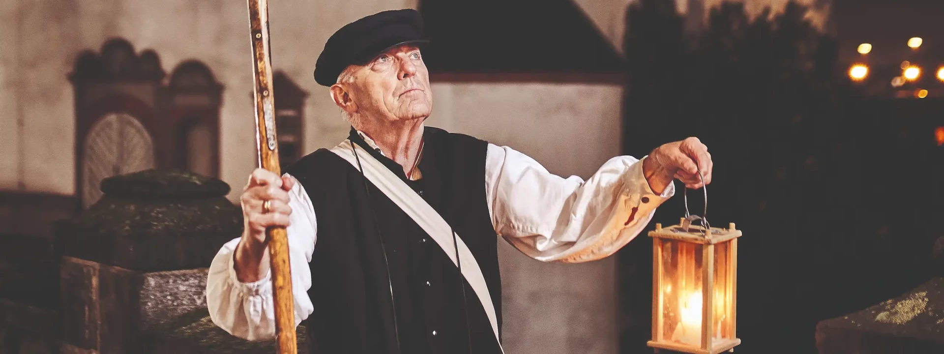 Stadsgids, verkleed als voormalige nachtwaker, houdt een lantaarn en hellebaard vast voor het Oude Kasteel in Koblenz © Koblenz-Touristik GmbH, Picture Colada