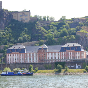 Dikasterialgebäude am Rheinufer vor der Festung Ehrenbreitstein mit dem Rhein im Vordergrund © Koblenz-Touristik GmbH