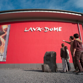 Gebäude des Lava-Dome Mendig von außen, Familie mit zwei Kindern steht davor  ©Kappest