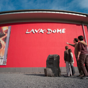 Gebäude des Lava-Dome Mendig von außen, Familie mit zwei Kindern steht davor  © Kappest