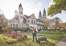 Gästeführer mit Bollerwagen vor der Basilika St. Kastor im Blumenhof