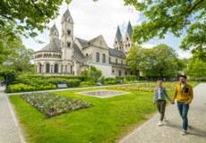 Pärchen geht Hand in Hand durch den Blumenhof hinter Basilika St. Kastor ©Koblenz-Touristik GmbH, Dominik Ketz