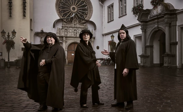 Bekleidet Stadtführer:innen stehen auf dem Jesuitenplatz in Koblenz bei Nacht