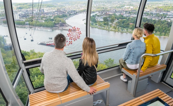 3 Personen in einer Kabine der Seilbahn Koblenz mit Blick auf dem Rhein, der Mosel und dem Deutschen Eck im Hintergrund
