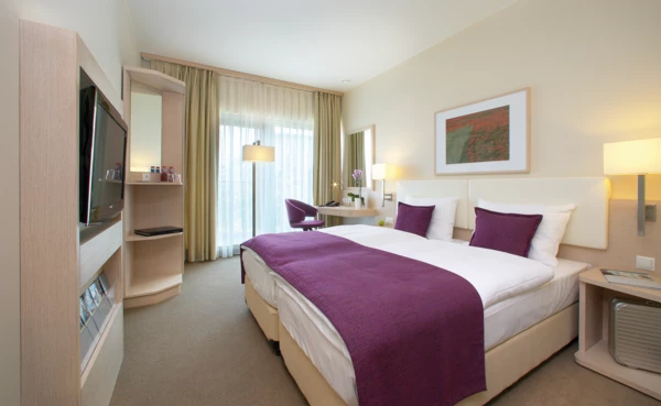 Hotelzimmer mit Teppichboden, Bodenfenster und Fernseher