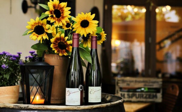 Zwei Weinflaschen und eine Laterne stehen neben einem Blumentopf auf einem Holzfass beim Eingang des Weinguts Spurzem ©Koblenz-Touristik GmbH