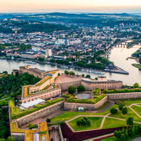 Luftaufnahme über der Festung Ehrenbreitstein mit der Stadt Koblenz und dem Zusammenfluss von Rhein und Mosel im Hintergrund. © 