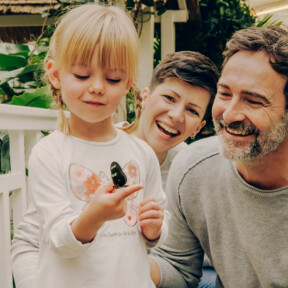 Familie im Schmetterlingsgarten in Sayn lachen während Tochter einen Schmetterling auf ihrem Finger beobachtet ©Koblenz-Touristik GmbH, Philip Bruederle
