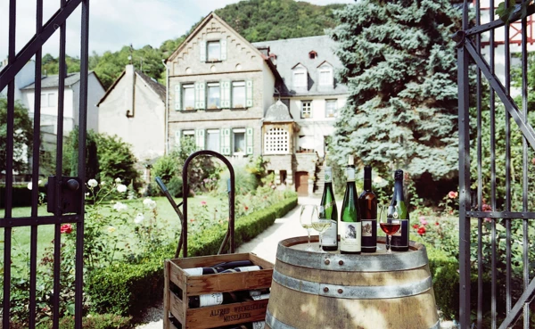 Weingut Weckbecker mit Weinflaschen auf einem Fass vor dem Tor