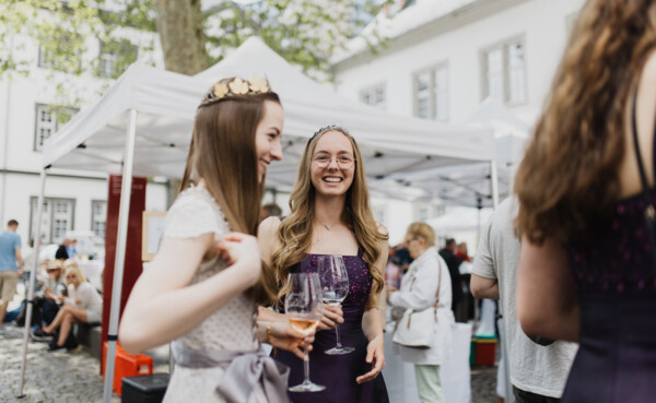 Weinköniginnen lachen mit Weingläsern in den Händen bei einem Weinfest am Rathausplatz in Koblenz ©Koblenz-Touristik GmbH, Picture Colada
