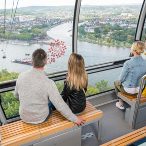 4 Personen in einer Kabine der Seilbahn Koblenz mit Blick auf dem Rhein, der Mosel und dem Deutschen Eck im Hintergrund © Koblenz-Touristik GmbH, Dominik Ketz