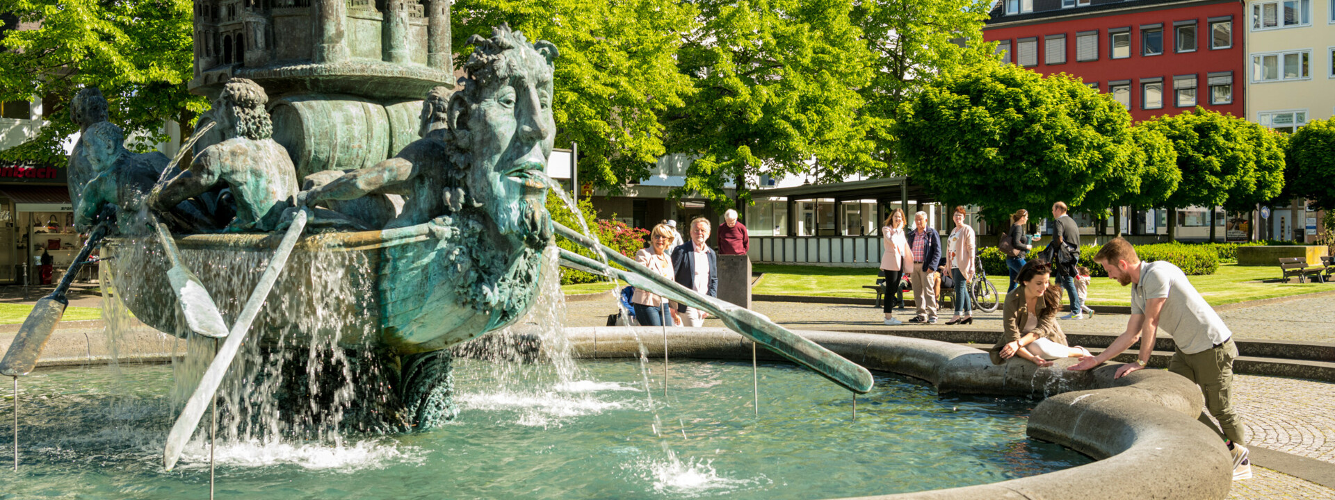 Brunnen "Historiensäule" auf dem Görresplatz in Koblenz umgeben von kleinen Menschengruppen ©Koblenz-Touristik GmbH, Dominik Ketz
