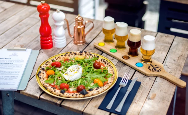 Pizza mit verschiedenen Bieren serviert auf dem Tisch vom Restaurant 3Hefen