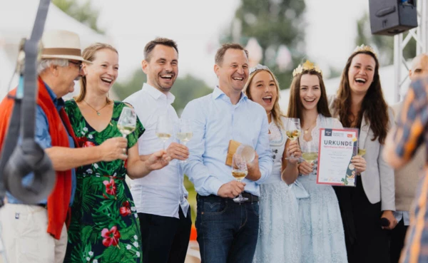 Oberbürgermeister, Koblenzer Weinmajestäten und Winzer bei der Krönung des WeinKaiserWeins, alle halten ein Glas Wein in der Hand, eine Person hält die Gewinnerurkunde in der Hand