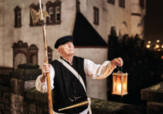 Stadtführer, bekleidet als früherer Nachtwächter, hält Laterne und Hellebarde vor der Alten Burg in Koblenz ©Koblenz-Touristik GmbH, Picture Colada