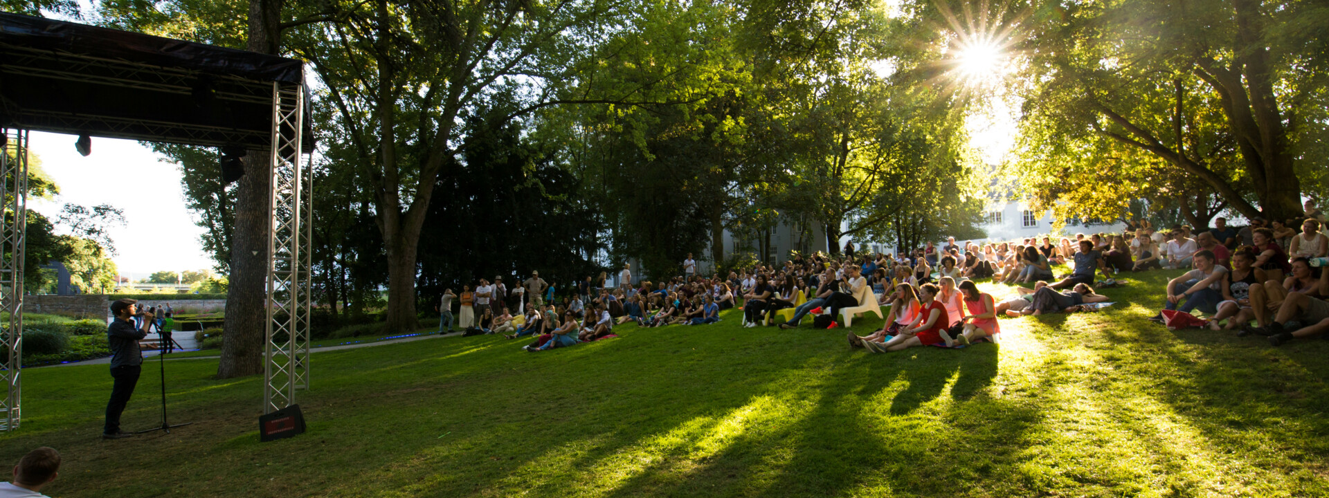 Menschengruppen sitzen auf dem Rasen im Schlosspark und hören einem Dichter zu ©Koblenz-Touristik GmbH, Henry Tornow