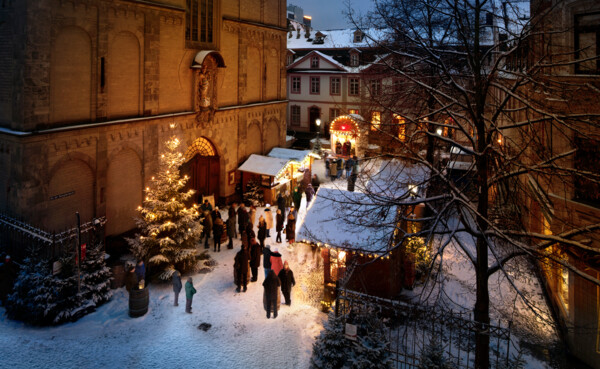 Menschen reden, essen und trinken vor beschmuckten und mit Schnee bedeckten Ständen auf dem Vorplatz der Liebfrauenkirche in Koblenz © Koblenz-Touristik GmbH, Gauls