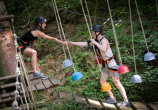 Zwei Teenager mit Kletterausrüstung balancieren auf einem Kletterparcours ©Kletterwald Sayn