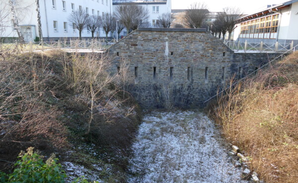 Graben mit einer gemauerten Wand mit kleinen Spalten ©Thomas Dillenburg