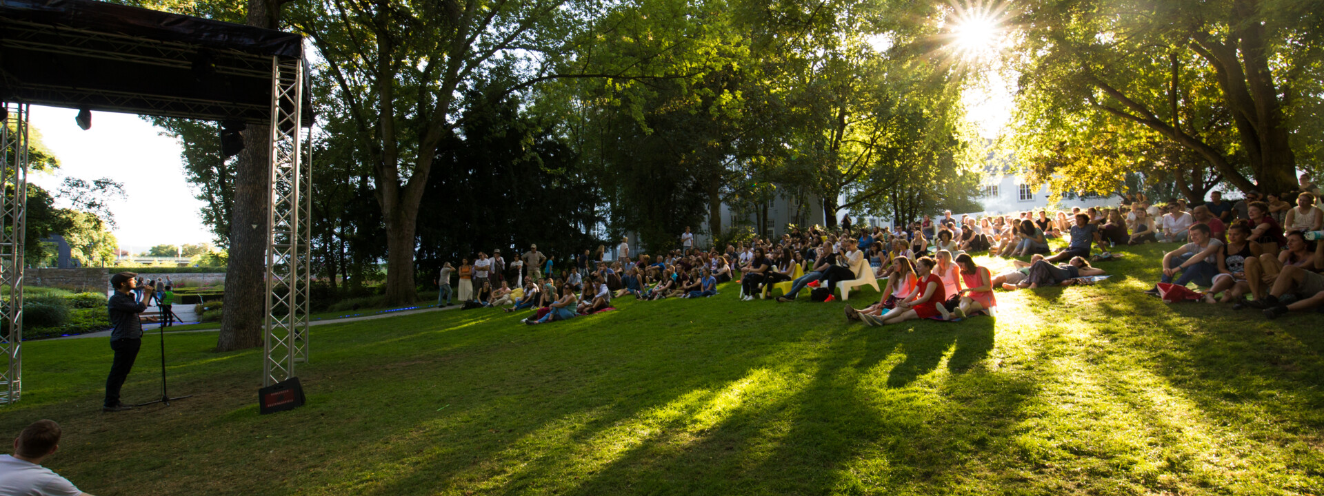 Menschengruppen sitzen auf dem Rasen im Schlosspark und hören einen Dichter zu ©Koblenz-Touristik GmbH, Henry Tornow