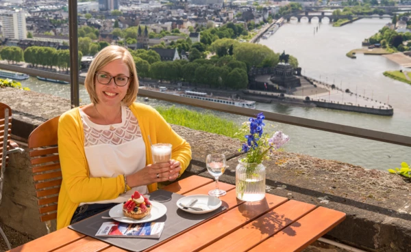 Frau sitzt mit einem Latte Macchiato und Kuchen im Café auf der Festung Ehrenbreitstein am Deutschen Eck