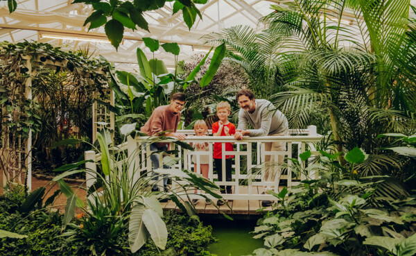 Familie im Schmetterlinggarten in Sayn stehen auf einer kleinen Brücke und erstaunen die Pflanzen und Schmetterlingen ©Koblenz-Touristik GmbH, Philip Bruederle