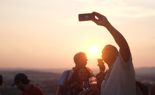 Mann macht von sich ein Selfie, im Hintergrund Sonnenuntergang  ©PlusPunktFilm