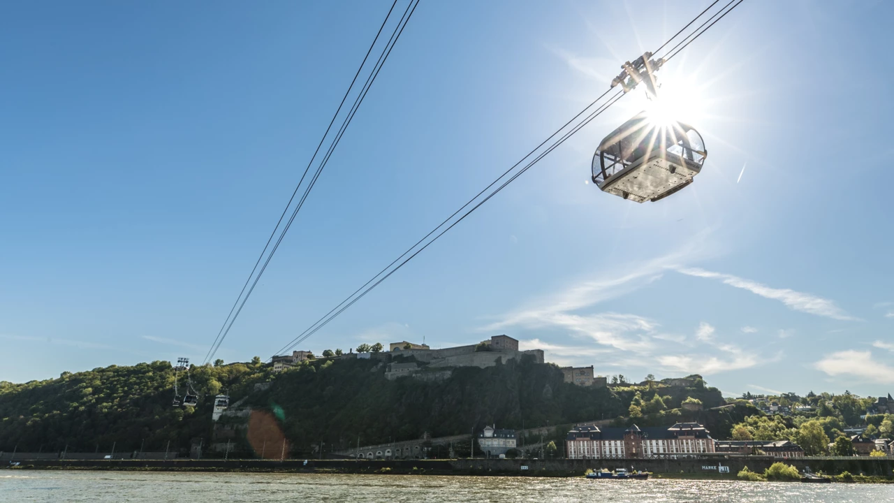 Koblenz Cable Car backlit by the sun as it rides over the Rhine river