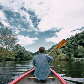 Mann von hinten, der in einem Kanu mit Paddel sitzt und über die Lahn fahrt  ©Koblenz-Touristik GmbH, Philip Bruederle