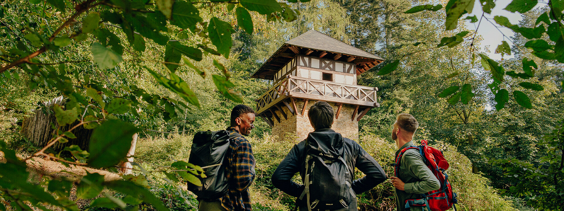 Wandergruppe steht vor einem Römerturm im Wald ©Koblenz-Touristik GmbH, Philip Bruederle